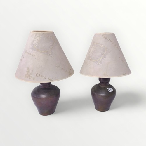 333 - A pair of copper clad table lamps having 'script' shades, 56cm high inclusive.