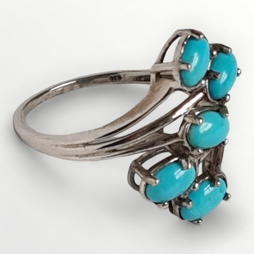 12 - A 925 silver and turquoise cabochon crossover ring, size U. Shipping group (A).