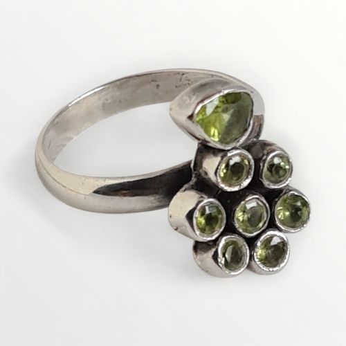 47 - Silver ring in the form of a flower set with green stones. Shipping group (A).