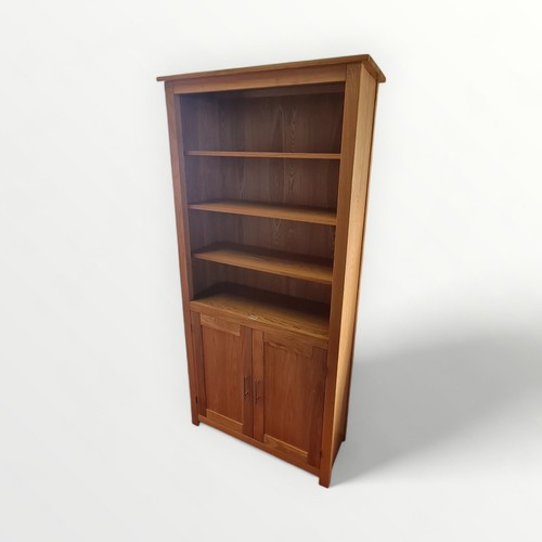 273 - Good quality modern light oak bookcase, adjustable open shelves over twin cupboard doors. 192 x 93cm... 