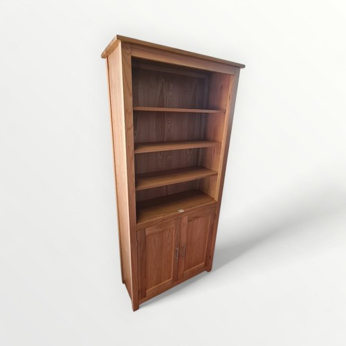 273 - Good quality modern light oak bookcase, adjustable open shelves over twin cupboard doors. 192 x 93cm... 