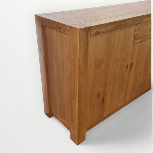 304 - Modern light oak side board having central drawer over cupboard door, flanked by two larger cupboard... 