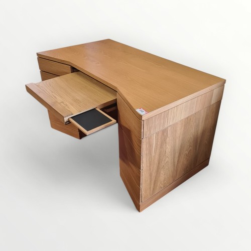 312 - As new designer modern light oak desk, having central slide out keyboard shelf flanked by two drawer... 