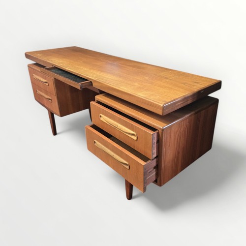 133 - G Plan teak dressing table with 'floating' top over two columns of two drawers. 71 x 152 x 46cm.