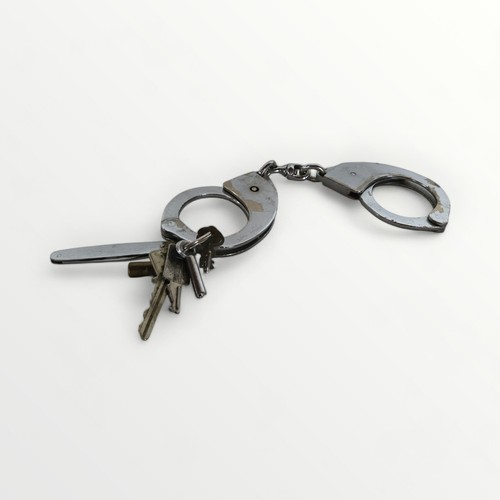 81 - A selection of Police metal handcuffs and a whistle. Shipping group (A).