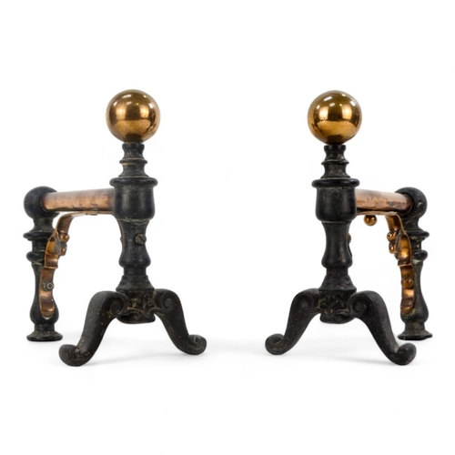 11 - A pair of iron and copper fire dogs - in the decorative arts style with ball finials, 22cm high.