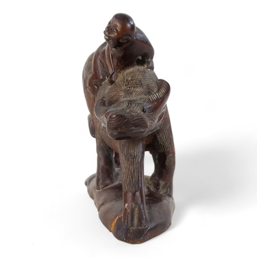 262 - An early 20th century carved hardwood figure - seated astride a wild ox, 15cm wide.