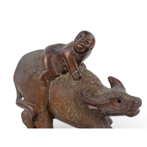 262 - An early 20th century carved hardwood figure - seated astride a wild ox, 15cm wide.