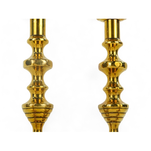 32 - A pair of 19th century brass candlesticks - of baluster form, with square canted bases, 23cm high, t... 