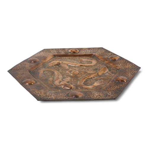 5 - An early 20th century copper wall plaque - hexagonal repousse decorated with three fish, 34cm wide.