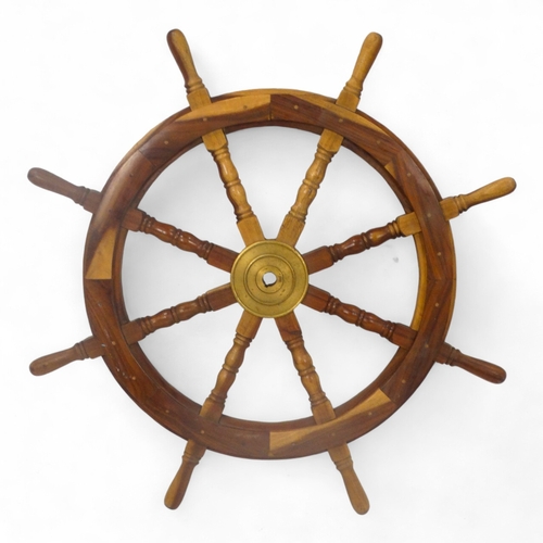 103 - A wooden ship's wheel - with eight turned spokes and brass centrepiece, diameter 90cm.