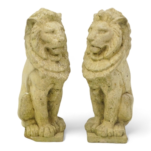 130 - A pair of reconstituted stone lions - height 34cm.