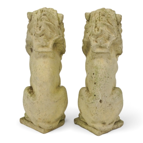 130 - A pair of reconstituted stone lions - height 34cm.