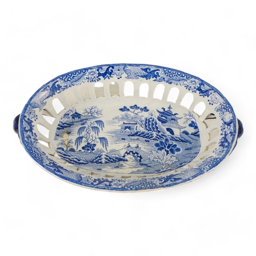 168 - An early 19th century blue and white pottery bread basket - oval with twin handles and decorated wit... 