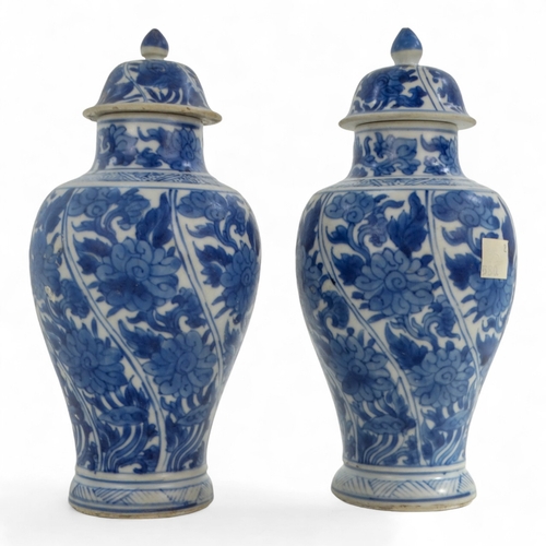 268 - A pair of late 17th century Chinese blue and white baluster vases with covers - painted with lotus s... 