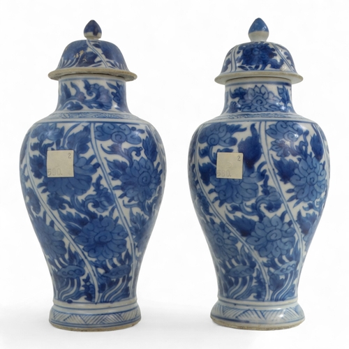 268 - A pair of late 17th century Chinese blue and white baluster vases with covers - painted with lotus s... 