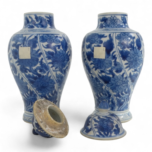 268 - A pair of late 17th century Chinese blue and white baluster vases with covers - painted with lotus s... 