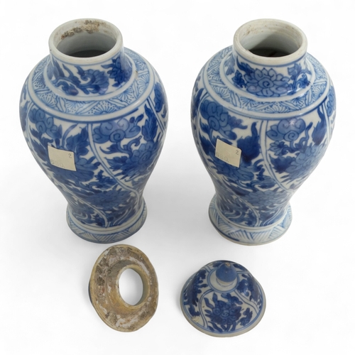 268 - A pair of late 17th century Chinese blue and white baluster vases with covers - painted with lotus s... 