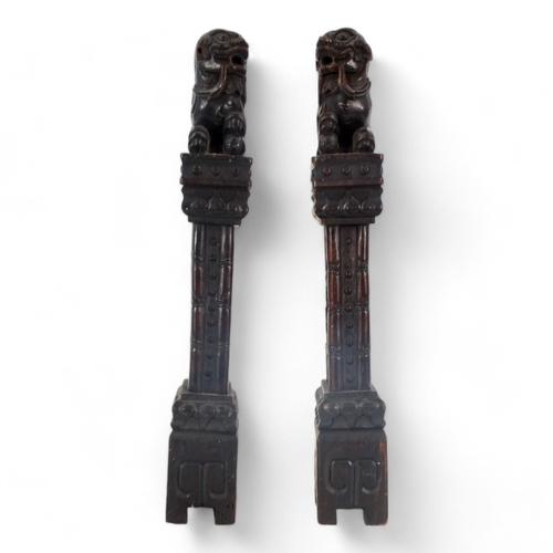 269 - A pair of late 19th/early 20th century carved hardwood table screen stiles - surmounted by dog of fo... 