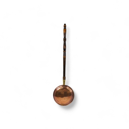 33 - A late 19th century copper warming pan - of typical circular form, with a turned wooden handle, 102c... 