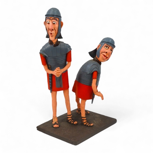 38 - A comical papier mache Roman figure group - modelled as two quizzical centurions, 85cm high.