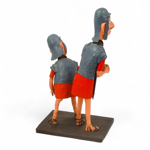 38 - A comical papier mache Roman figure group - modelled as two quizzical centurions, 85cm high.