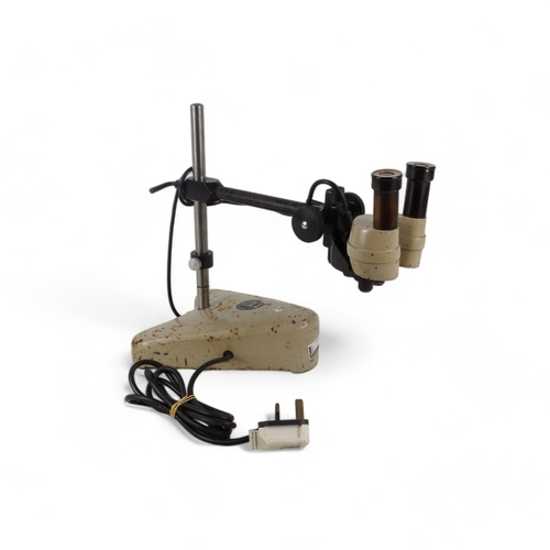 43 - A vintage stereo microscope - height adjustable and incorporating a powered light source.