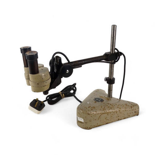 43 - A vintage stereo microscope - height adjustable and incorporating a powered light source.