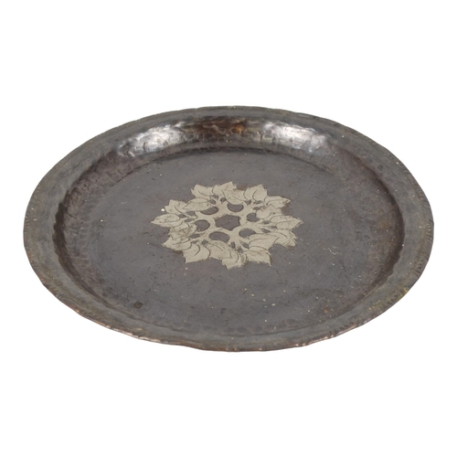 52 - Hugh Wallis (British, 1871-1943) a copper and pewter dish - decorated with a band of foliage, signed... 