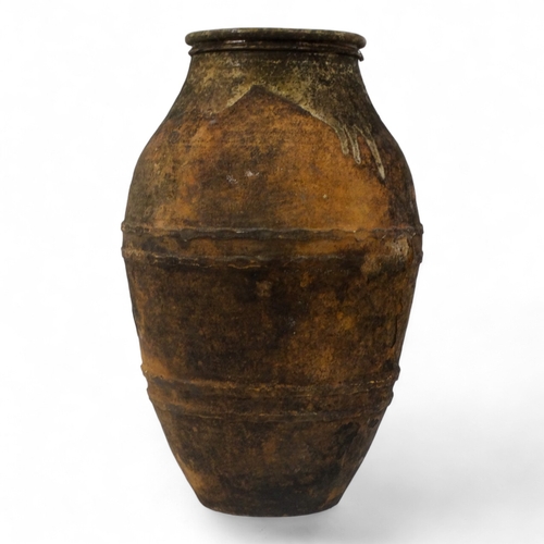 68 - A terracotta olive jar - partially glazed, with turned rim and abstract decoration, height 66cm, dia... 