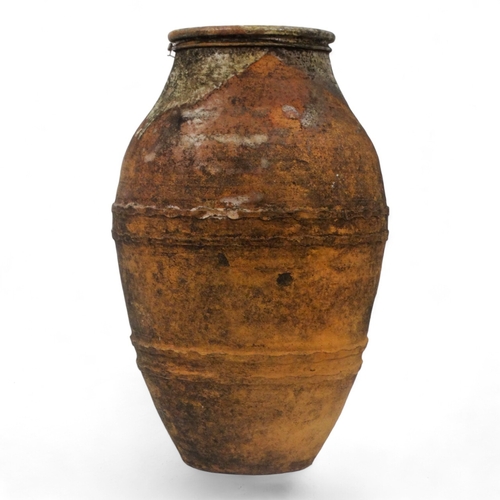 68 - A terracotta olive jar - partially glazed, with turned rim and abstract decoration, height 66cm, dia... 