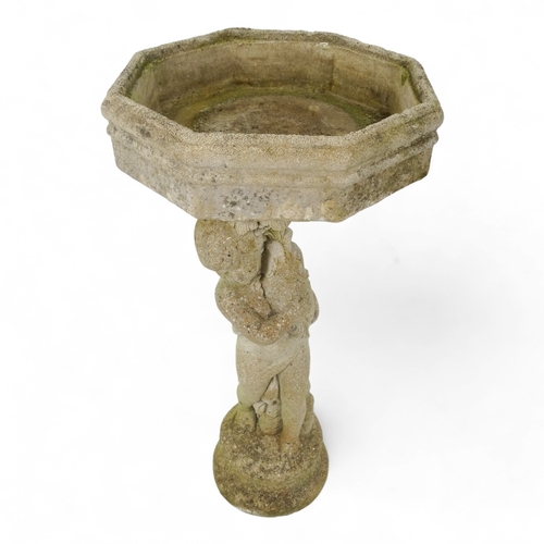 80 - A reconstituted stone bird bath modelled as a boy holding a fish - raised on a two tier plinth and w... 