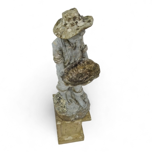 95 - A resin statue modelled as a boy holding a shell - on a reconstituted stone floral decorated plinth,... 