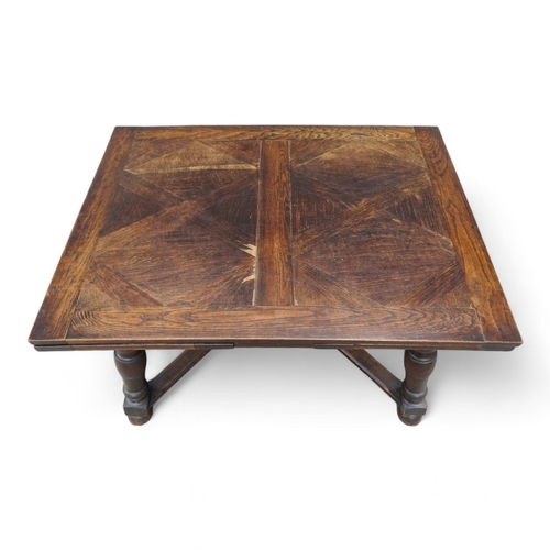 950 - A Spanish style oak draw-leaf table - the rectangular top with geometric veneers, on splayed square ... 