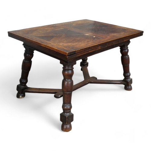 950 - A Spanish style oak draw-leaf table - the rectangular top with geometric veneers, on splayed square ... 