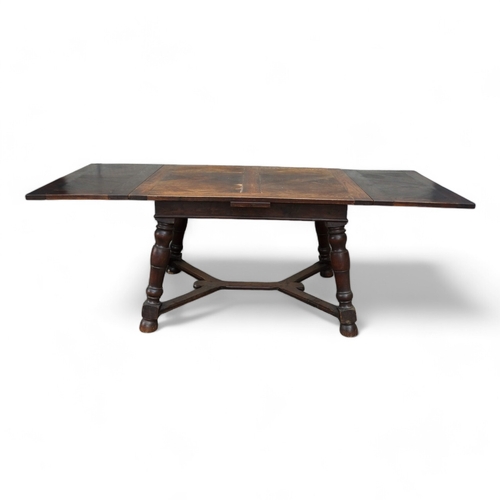 950 - A Spanish style oak draw-leaf table - the rectangular top with geometric veneers, on splayed square ... 