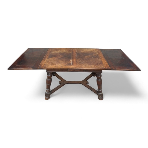 950 - A Spanish style oak draw-leaf table - the rectangular top with geometric veneers, on splayed square ... 