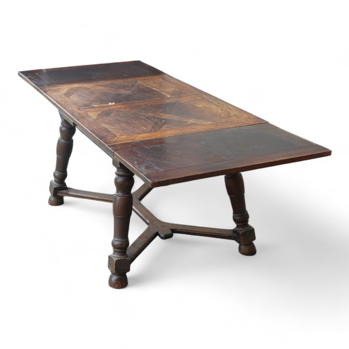 950 - A Spanish style oak draw-leaf table - the rectangular top with geometric veneers, on splayed square ... 