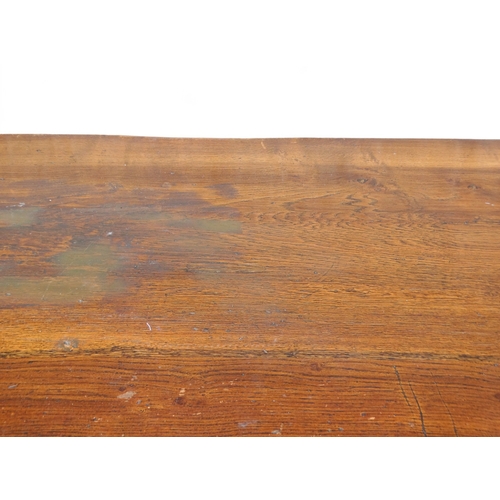 951 - A 17th century style oak refectory table - the cleated plank top above a carved frieze and square an... 