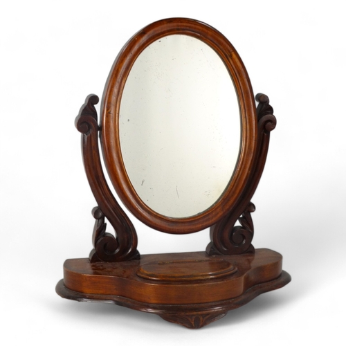 952 - A Victorian mahogany toilet mirror - with an oval plate between shaped supports on an ogee shaped ba... 