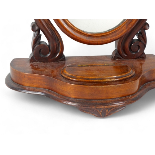 952 - A Victorian mahogany toilet mirror - with an oval plate between shaped supports on an ogee shaped ba... 