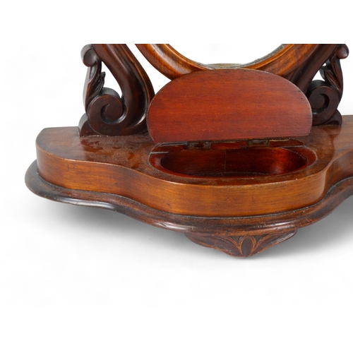 952 - A Victorian mahogany toilet mirror - with an oval plate between shaped supports on an ogee shaped ba... 