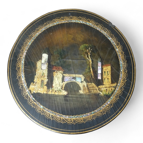 954 - A Victorian papier mache tilt top table - the circular top with lake scene within a mother-of-pearl ... 