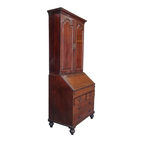 956 - A George III mahogany bureau bookcase - the upper section with shaped panel doors enclosing adjustab... 