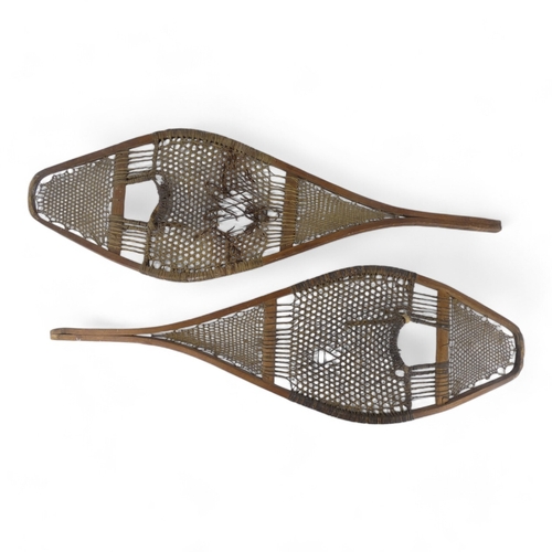 1 - A pair of vintage Huron style snow shoes - of traditional rawhide construction on ash frames.