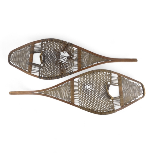 1 - A pair of vintage Huron style snow shoes - of traditional rawhide construction on ash frames.