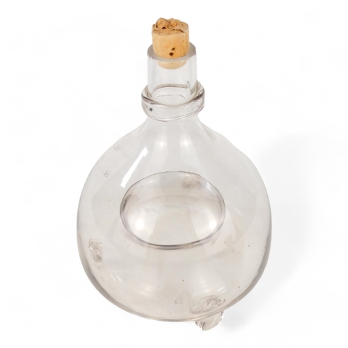 10 - A late Victorian clear glass fly trap - onion shaped and raised on three bracket feet, 18cm high.