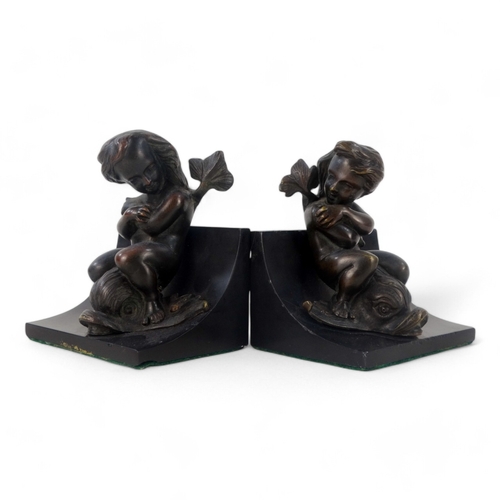 11 - A pair of bronze and slate book-ends - modelled as cherubs riding dolphins mounted on black slate, 1... 