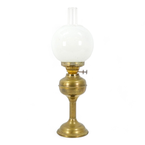 120 - An early 20th century brass oil lamp - with a milk glass globe shade, with a fluted column, 57cm hig... 