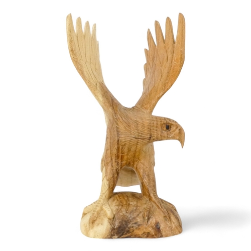 125 - A 20th century carved hardwood eagle - wings outstretched, 30cm high.